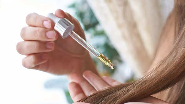 Woman applying hair serum to her hair